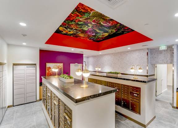 A kitchen with a purple wall and a mural of a flower on the ceiling.