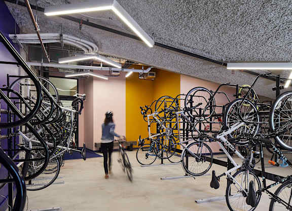 A person walks through a room full of bicycles.