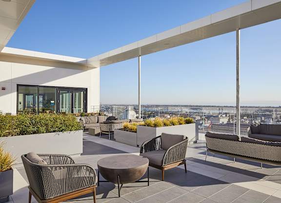 A patio with a table and chairs overlooking a cityscape.