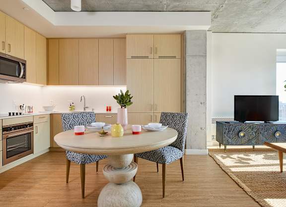A modern kitchen with a round table and chairs.