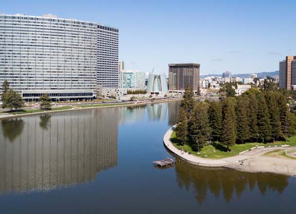 A large building sits next to a body of water with a boat in it.