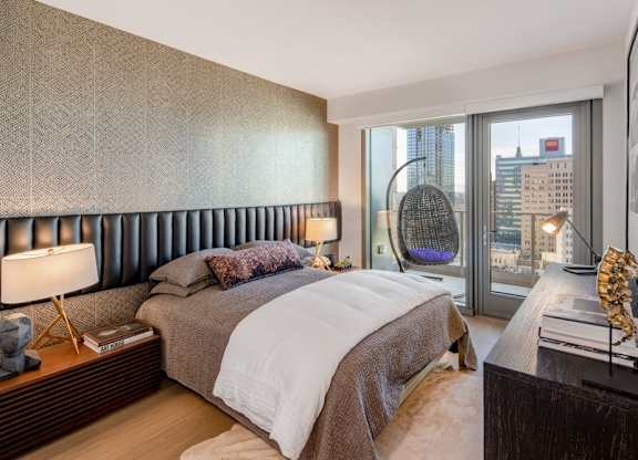 A bedroom with a large bed and a view of the city.