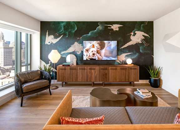 A living room with a large painting on the wall and a TV on a wooden cabinet.