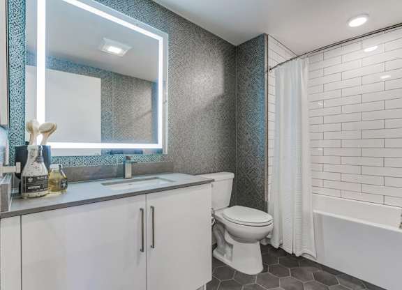 A white toilet sits next to a bathtub in a bathroom.