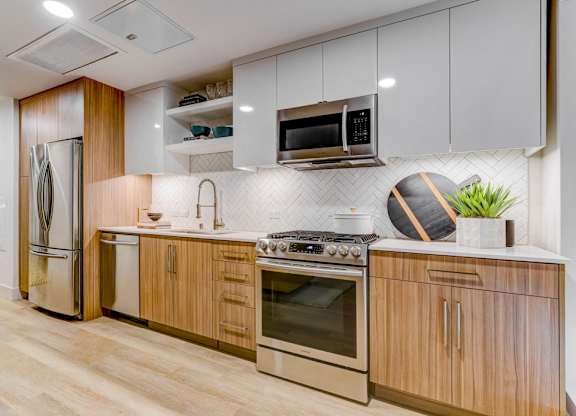 A modern kitchen with wooden cabinets and stainless steel appliances.