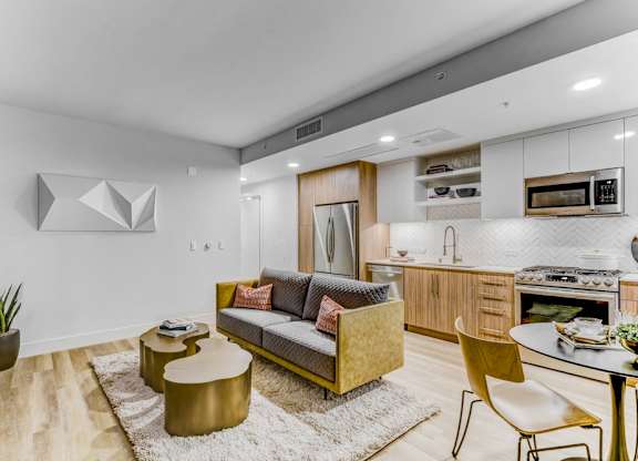 A modern living room with a yellow sofa and a white rug.