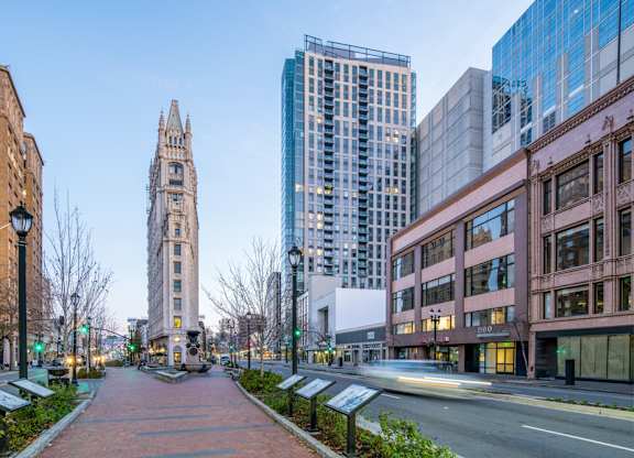 A city street with a tall building in the background.