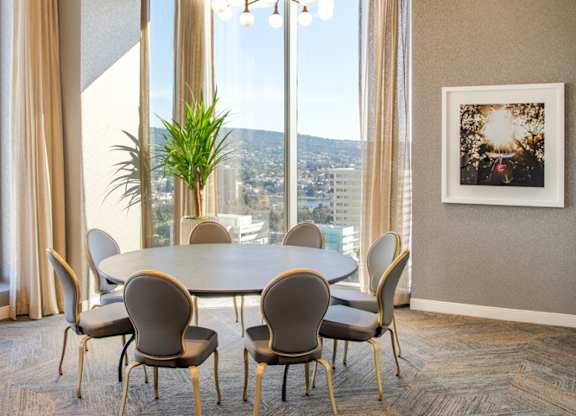 A dining room with a table and chairs and a view of the city.