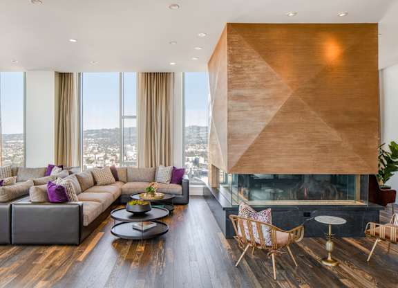 A modern living room with a fireplace and a view of the city.