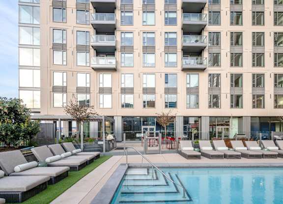 A large building with a pool in front of it.