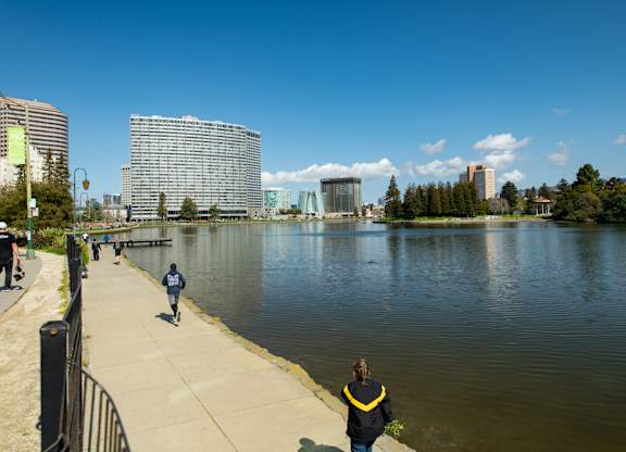 A person in a yellow jacket is standing by a body of water.