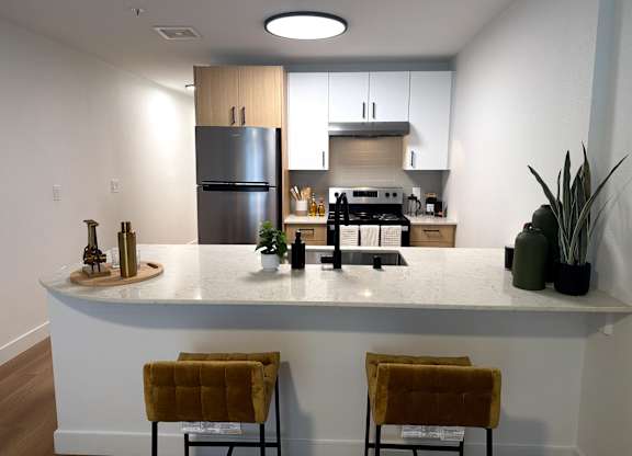 A kitchen with a white countertop and a refrigerator.