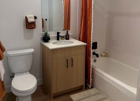 A white toilet sits next to a sink in a small bathroom.