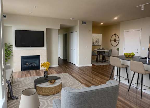 Open concept living room with fireplace and dining area at Axis Seattle Apartments, Washington, 98109