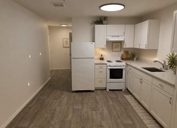 A kitchen with white appliances and wooden floors.