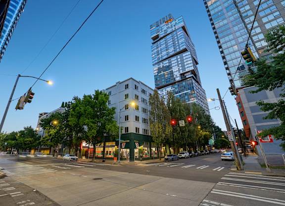 A city street with a traffic light and a building in the background.