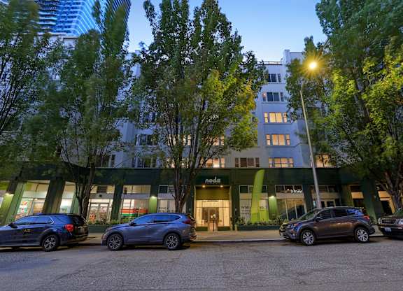 A Nonda store is located in a green building with cars parked in front.