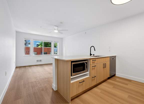 A kitchen with wooden floors and a white ceiling.