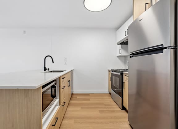 A modern kitchen with stainless steel appliances and wooden cabinets.