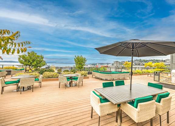 Rooftop deck with dining tables and city views at Axis Seattle Apartments, Seattle, 98109