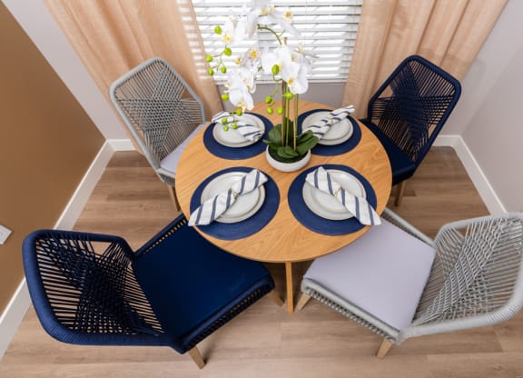 a dining room with a wooden table with blue chairs and a blue and white table