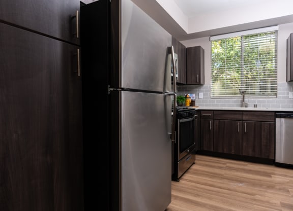 a kitchen with a stainless steel refrigerator and a window