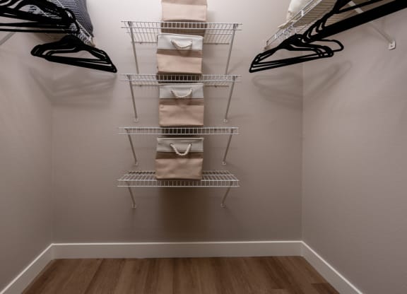 a closet with a rack with bags and shoes in it