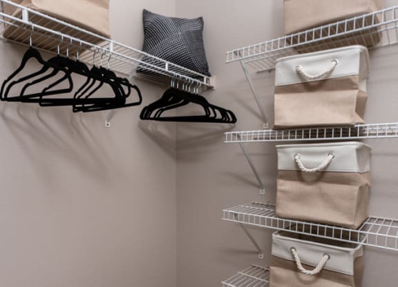 a walk in closet with bags and shelves