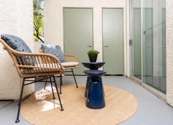 a patio with two chairs and a table and a door