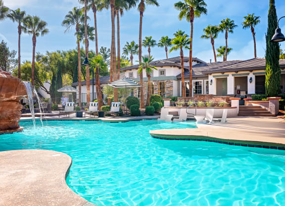 Spring Valley Apartments - Alicante - Pool with White Lounge Chairs, Palm Trees, Umbrella Tables, and View of Sundeck