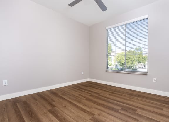 an empty room with wood floors and a window