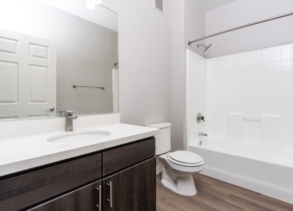 a bathroom with a toilet sink and shower and a mirror