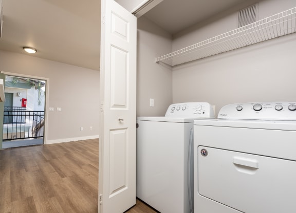Apartments for Rent in 89147, Spring Valley, NV - Alicante - Bathroom with Hardwood-Style Floor, Bathtub, Wood-Tone Cabinet, Mirror, and Laundry Closet with Washer and Dryer