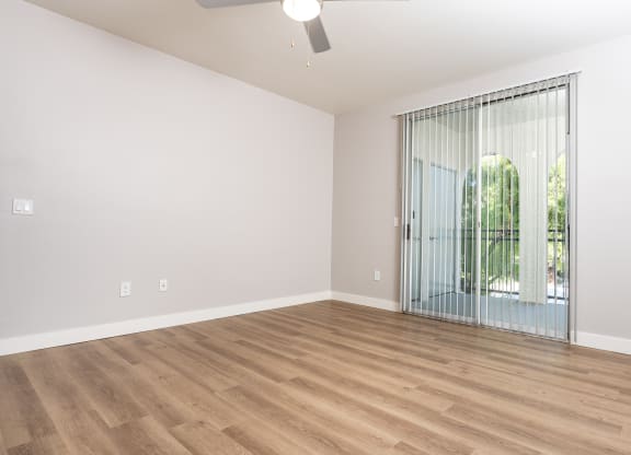 an empty living room with a sliding glass door to a patio
