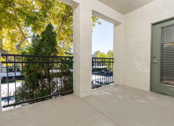 the view from the balcony of a condo with a green door and a balcony railing