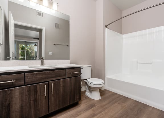 Apartments in Spring Valley for Rent - Alicante - Bathroom with Bath Tub, Shower, Wood-Style Flooring, and Large Mirror
