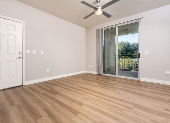 a living room with wood flooring and a ceiling fan