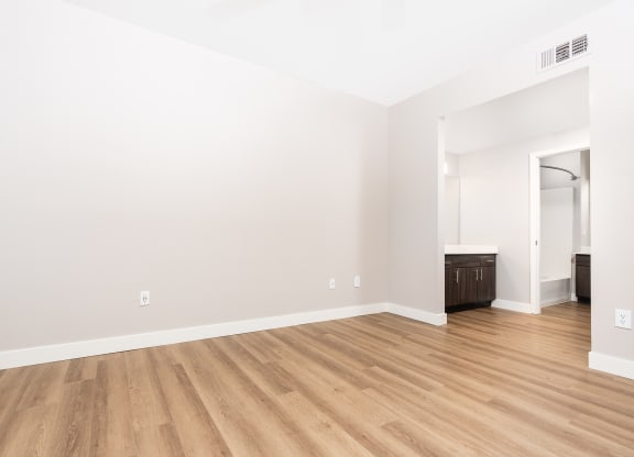 an empty living room with white walls and wood flooring