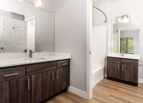a bathroom with wooden cabinets and a sink and a mirror