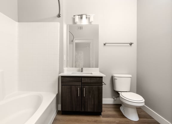 a bathroom with a toilet and a tub and a sink