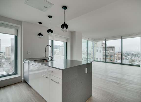 A modern kitchen with a large island and pendant lights.