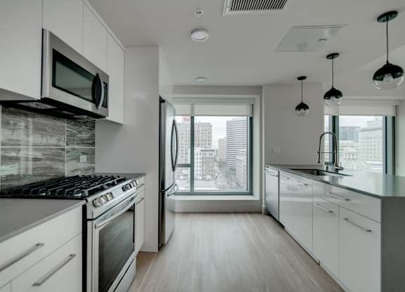 A modern kitchen with white cabinets and a black stove top.
