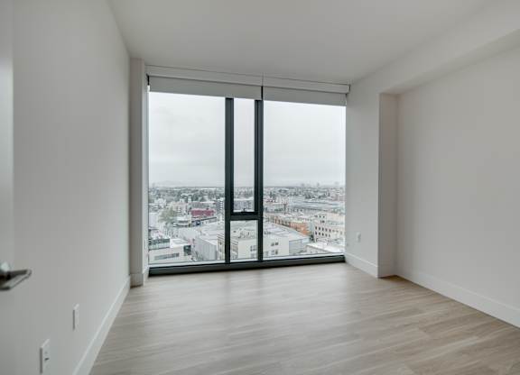 A room with a large window overlooking a cityscape.