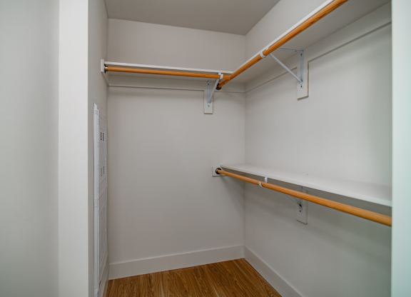 A white room with a shelf and a door.