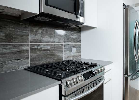 A modern kitchen with a stove and a microwave above it.