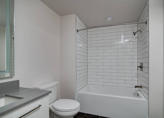 A white bathroom with a toilet, sink, and bathtub.