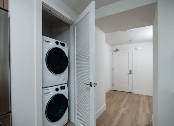 A laundry room with a washer and dryer stacked on top of each other.