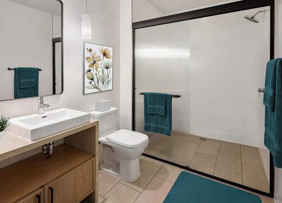 A bathroom with a white toilet, a sink, and a shower.