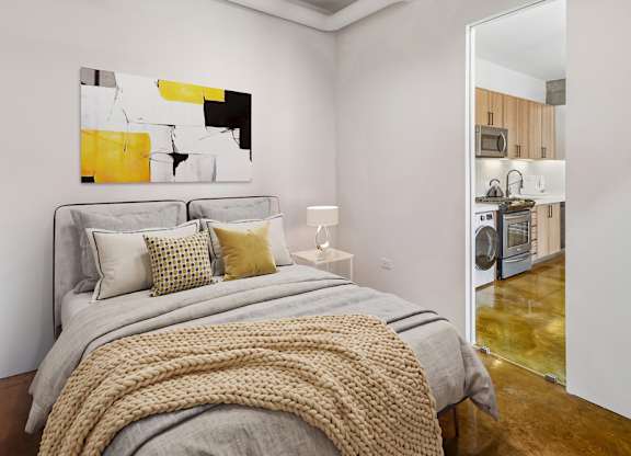 A bedroom with a large bed and a painting on the wall.