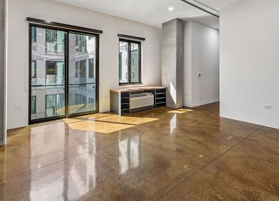 A room with a brown floor and a window.